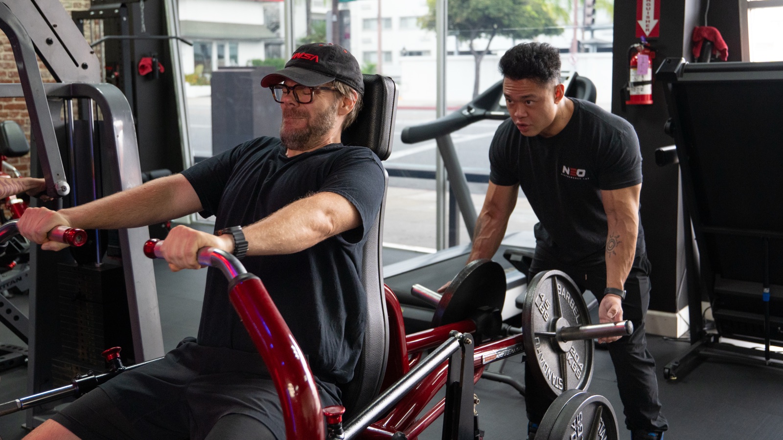 A NEO coach watching a client closely during a seated row